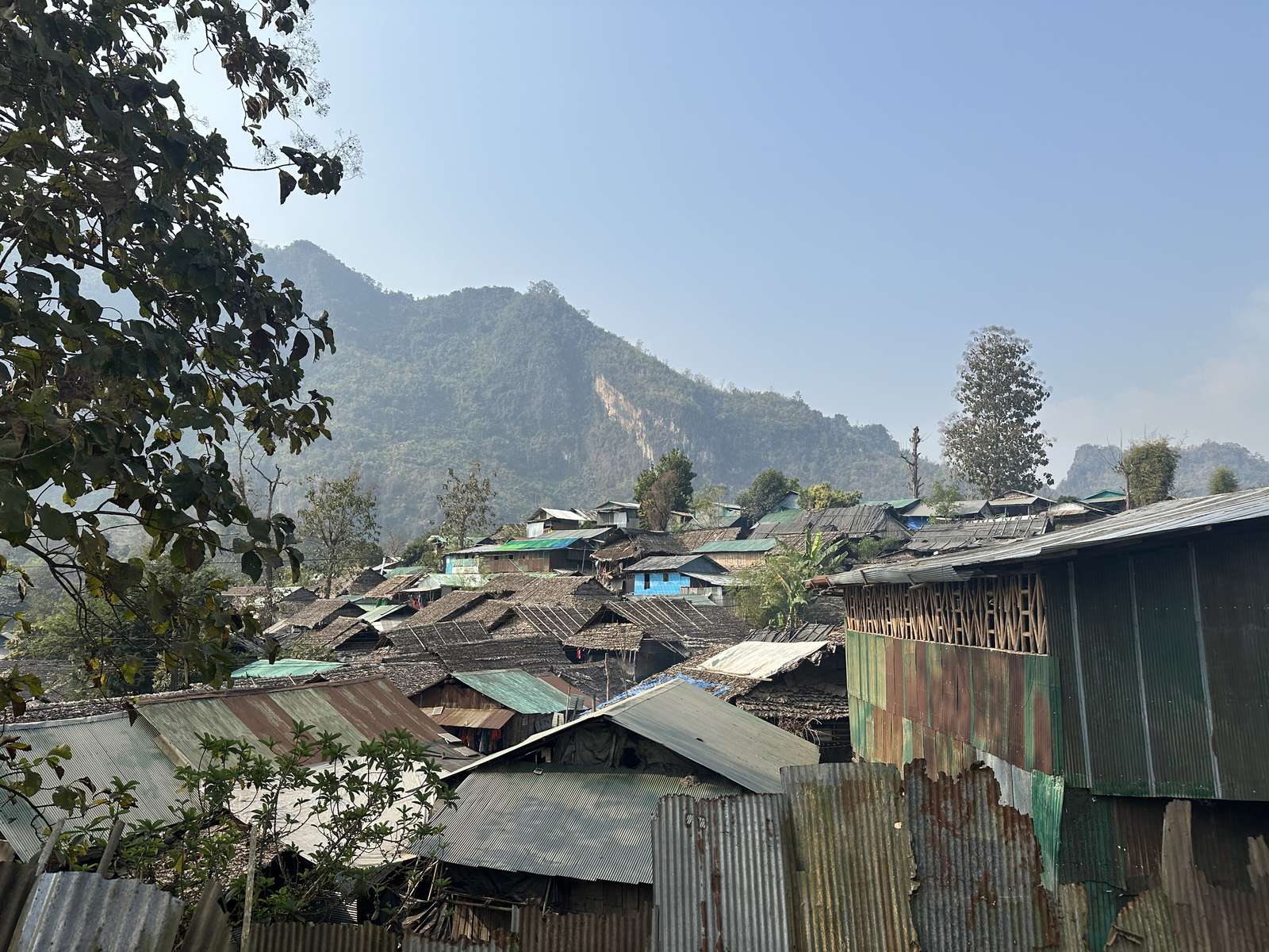 Mae La, Thailand, seen from a distance — houses and trees on a green hillside